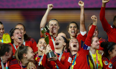 Spain women's national football team players smiling and cheering together while lifting the trophy in celebration after winning the FIFA Women's World Cup. Image used for Sportxparte news.