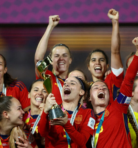 Spain women's national football team players smiling and cheering together while lifting the trophy in celebration after winning the FIFA Women's World Cup. Image used for Sportxparte news.