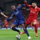 Ousmane Dembélé and Khvicha Kvaratskhelia of PSG battle Mohamed Salah of Liverpool in a Champions League clash at Anfield