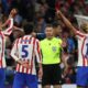 Atlético Madrid players Marc Pubill (#18), Johnny Cardoso (#5), and Marcos Llorente (#14) are protesting a decision by referee Danny Makkelie during their UEFA Champions League semi-final first leg against Arsenal. Image used for Sportxparte news.