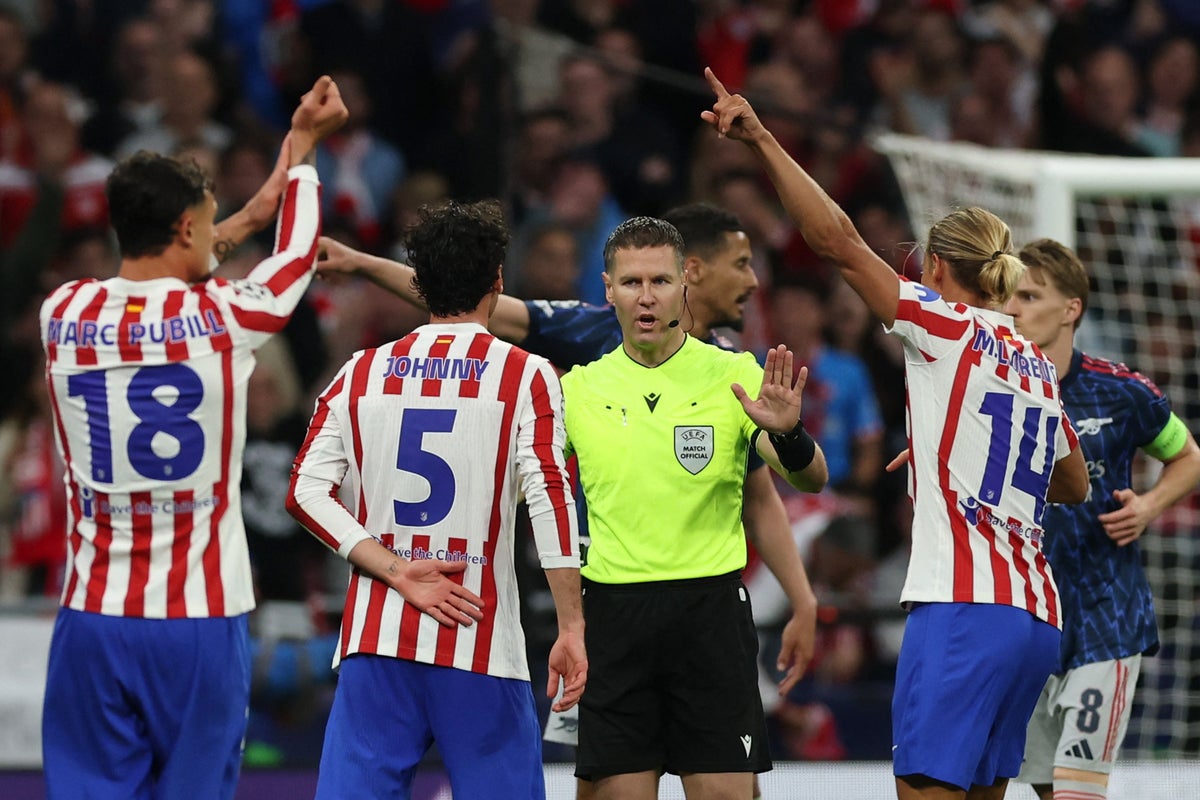 Atlético Madrid players Marc Pubill (#18), Johnny Cardoso (#5), and Marcos Llorente (#14) are protesting a decision by referee Danny Makkelie during their UEFA Champions League semi-final first leg against Arsenal. Image used for Sportxparte news.