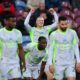 Manchester City forward Erling Haaland (center) celebrates with his arms raised after scoring the decisive goal in a 1-0 victory against Burnley at Turf Moor on April 22, 2026. He is joined in the foreground by teammates Jérémy Doku (front center), who provided the assist. Image used for Sportxparte news.