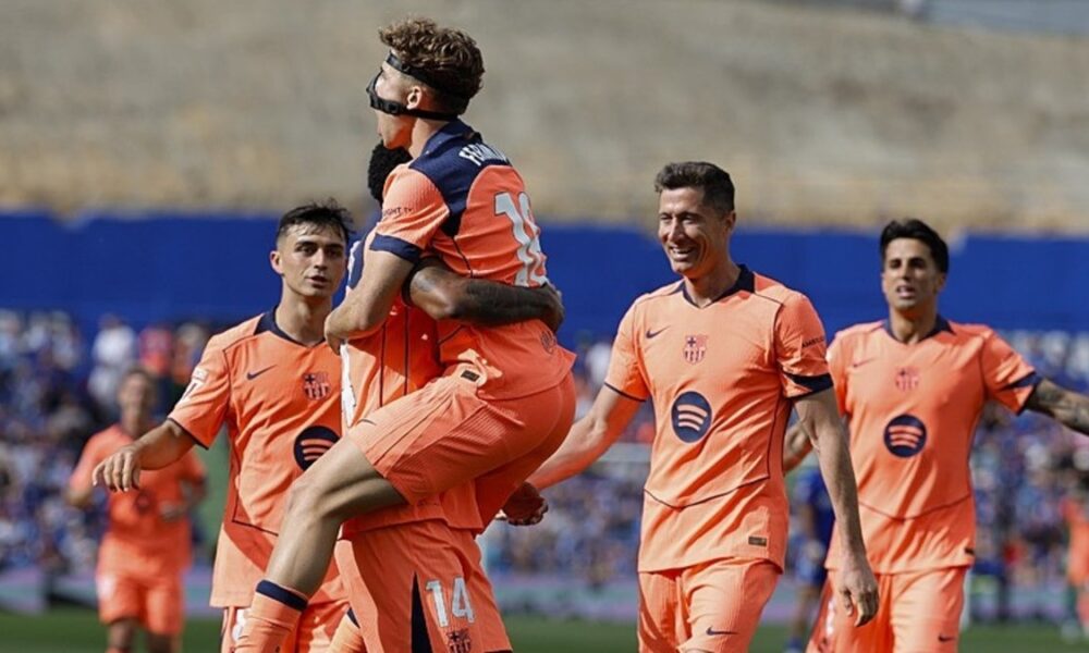 FC Barcelona forward Marcus Rashford carries teammate Fermín López (wearing a black protective facial mask) during a celebration after a goal against Getafe CF on April 25, 2026. Robert Lewandowski and Pedri are seen smiling in the background as the team celebrates at the Estadio Coliseum. Image used for Sportxparte news Roundup.