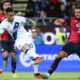 Inter Milan forward Lautaro Martínez, wearing a white away kit with the number 10, strikes a low shot toward the goal while Cagliari defender Alberto Dossena slides in to block during a Serie A football match at the Sardegna Arena. Image used for Sportxparte news.