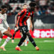 Portuguese defender Tiago Santos of Lille OSC (left, in white) and midfielder Reda Belahyane of OGC Nice (right, in red and black) competing for the ball during a Ligue 1 fixture. Image used for Sportxparte news.