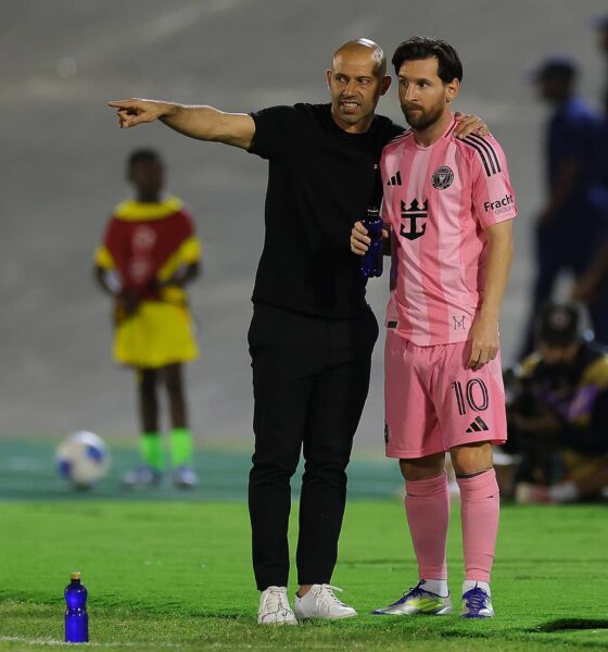 Lionel Messi and coach Javier Mascherano on the pitch in the Inter Miami 24/25 Home Authentic Jersey. Messi wears the pink "Euforia" kit with his iconic number 10, standing next to Mascherano in all-black sideline gear during an Inter Miami CF match. Image used for Sportxparte news.