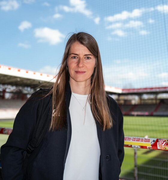Marie-Louise Eta, the first female head coach in Bundesliga history, is standing at the FC Union Berlin stadium. Image used for Sportxparte news.