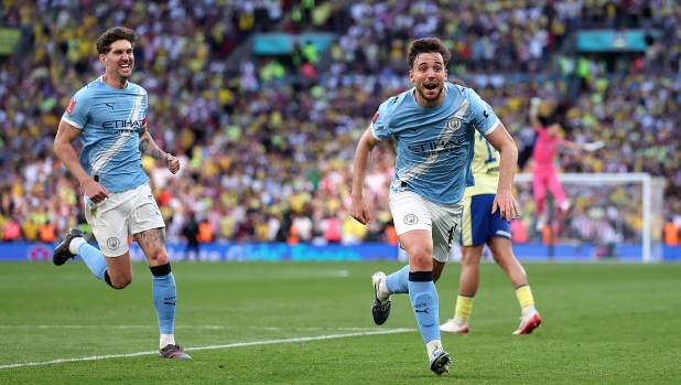 Nico González of Manchester City is celebrating a decisive late goal during a 2-1 victory over Southampton in the FA Cup semi-final. Behind him to the left, teammate John Stones joins in the celebration. Image used for Sportxparte news roundup.