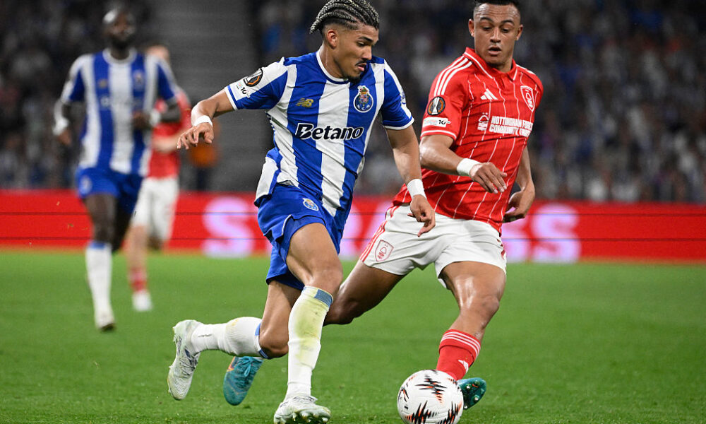 FC Porto winger William Gomes in a blue and white striped kit controls the ball while being pursued by a Nottingham Forest player in a red pinstriped kit during their 2025/26 UEFA Europa League quarterfinal at the Estádio do Dragão. Image used for Sportxparte news.