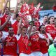 Arsenal captain Martin Ødegaard hoisting the Premier League trophy surrounded by his ecstatic teammates following the final match of the 2025–26 season. Image used for Sportxparte news.