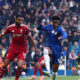 Liverpool forward Cody Gakpo (wearing number 18) and Chelsea defender Josh Acheampong (wearing number 34) during a Premier League match. This specific encounter took place at Stamford Bridge on October 4, 2025, where Chelsea secured a 2-1 victory through a 95th-minute winner by Estevao. Image used for Sportxparte news.