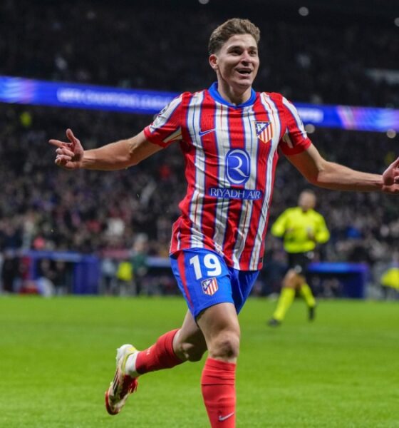 Atlético Madrid forward Julián Álvarez celebrates a goal on the pitch during a match. He wears the club's traditional red-and-white striped jersey with blue shorts emblazoned with the number 19. Image used for Sportxparte news.