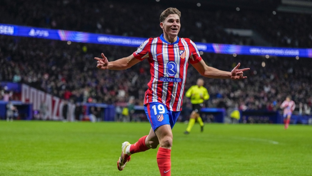 Atlético Madrid forward Julián Álvarez celebrates a goal on the pitch during a match. He wears the club's traditional red-and-white striped jersey with blue shorts emblazoned with the number 19. Image used for Sportxparte news.