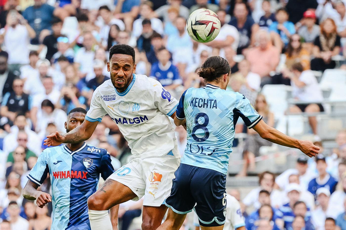 Ligue 1 match between Olympique de Marseille and Le Havre AC, where Marseille's forward Pierre-Emerick Aubameyang and Le Havre's midfielder Yassine Kechta are competing for a header. Image used for Sportxparte news.