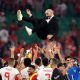 Moroccan national football team players enthusiastically throw their manager, Walid Regragui, into the air in celebration on the pitch. Image used for Sportxparte news.