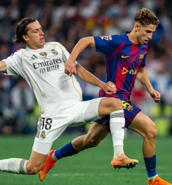 Real Madrid's Alvaro Carreras (#18) performing a sliding tackle on FC Barcelona's Fermin Lopez during the El Clásico La Liga match at the Santiago Bernabéu. Image used for Sportxparte news.