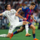 Real Madrid's Alvaro Carreras (#18) performing a sliding tackle on FC Barcelona's Fermin Lopez during the El Clásico La Liga match at the Santiago Bernabéu. Image used for Sportxparte news.