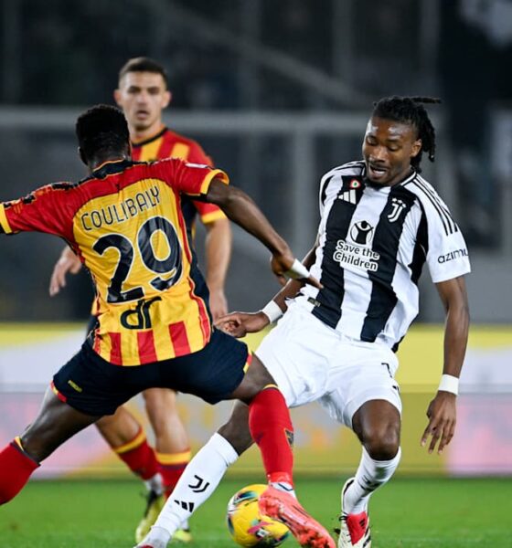 Serie A football match showing Khéphren Thuram of Juventus in a black-and-white striped jersey dribbling the ball. He is being closely defended from behind by Lameck Banda of US Lecce, who is wearing a yellow and red striped kit with the number 29. Image used for Sportxparte news.