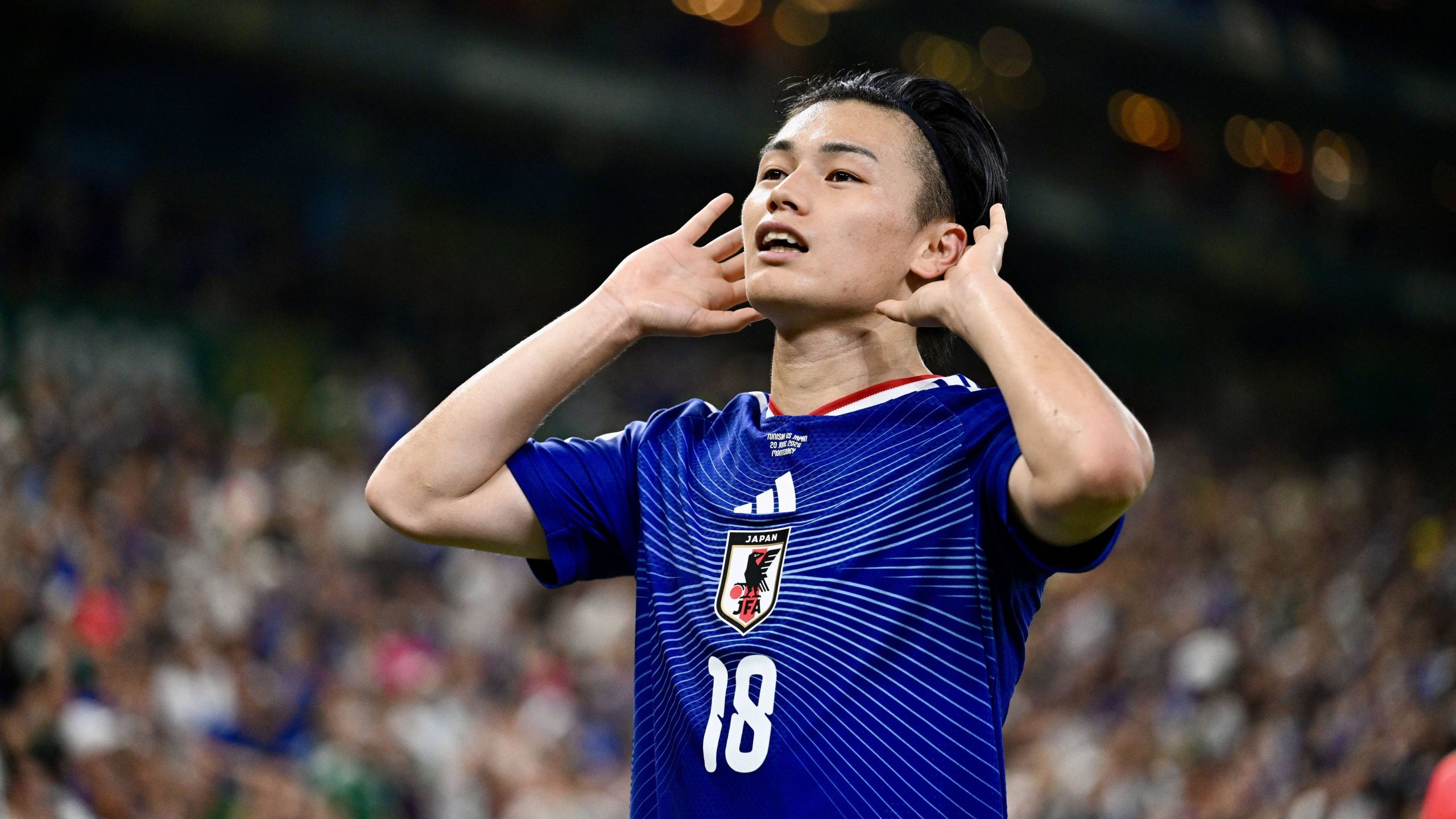 Japan national football team striker Ayase Ueda celebrates his historic second goal against Tunisia by raising both hands to his ears during the 2026 FIFA World Cup group stage match at the Estadio Monterrey in Mexico. Image used for Sportxparte news.