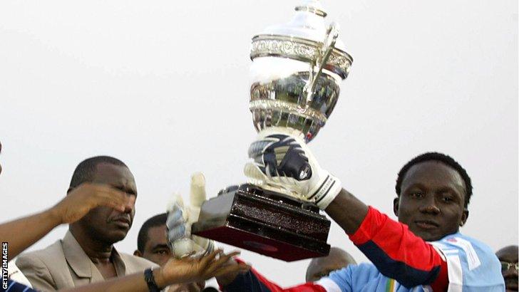 Nigerian goalkeeper Dele Aiyenugba lifting the CAF Super Cup trophy after winning the tournament with Enyimba FC. Image used for Sportxparte news