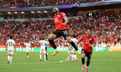 Egypt's Mohamed Salah leaps high into the air in a mid-air celebration alongside teammate Omar Marmoush after scoring against New Zealand during the 2026 FIFA World Cup. Image used for Sportxparte news.