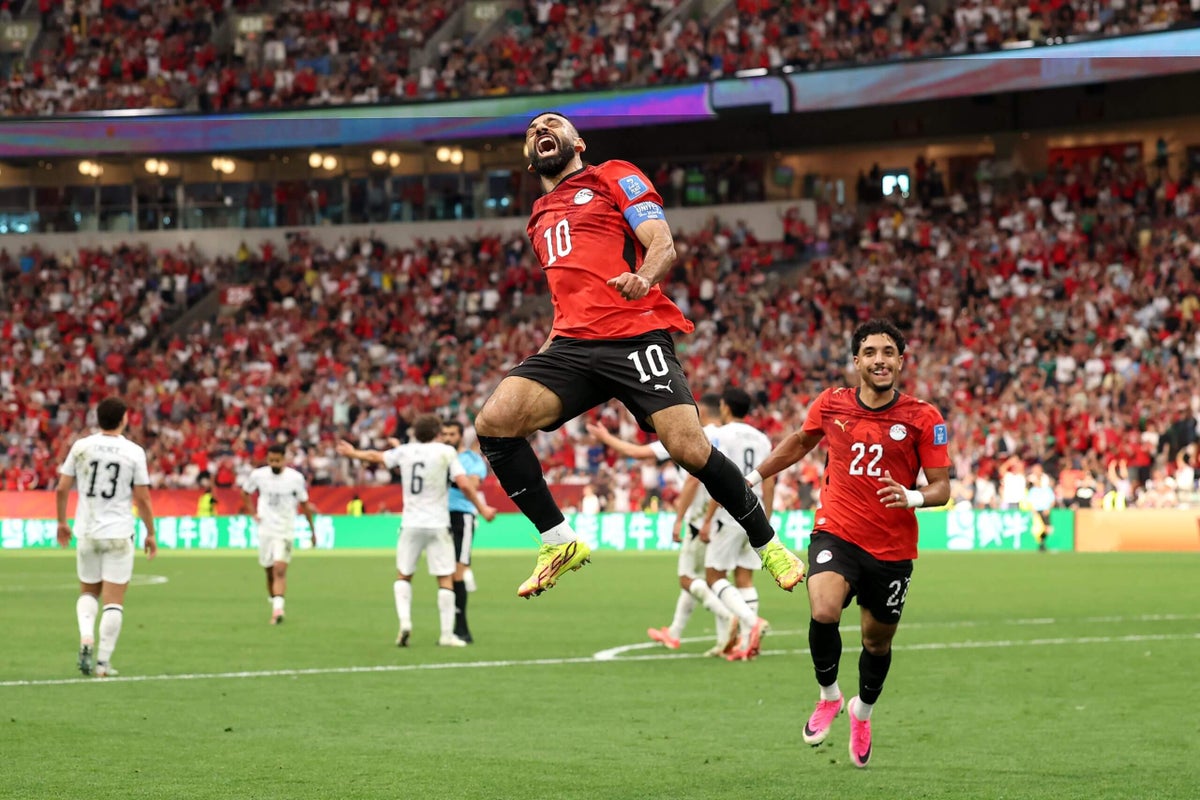 Egypt's Mohamed Salah leaps high into the air in a mid-air celebration alongside teammate Omar Marmoush after scoring against New Zealand during the 2026 FIFA World Cup. Image used for Sportxparte news.