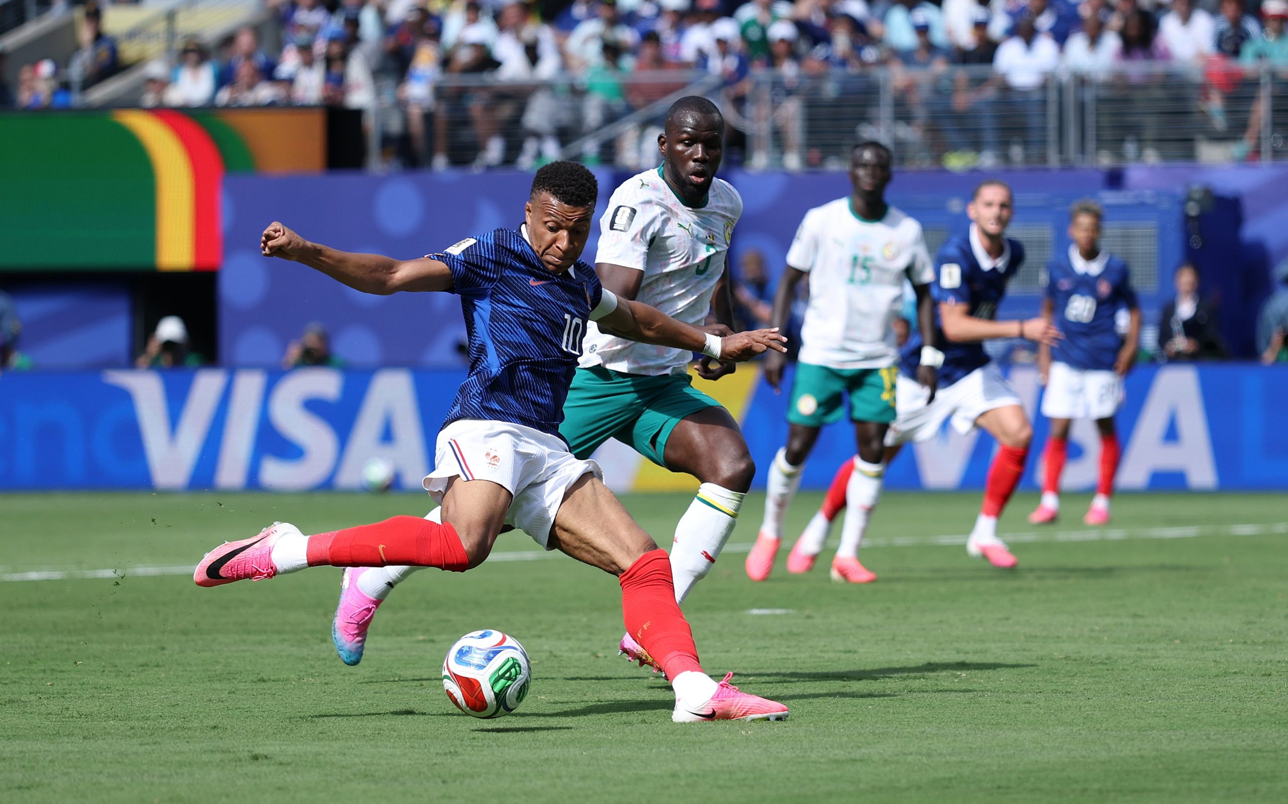 French forward Kylian Mbappé taking a shot under pressure from Senegal defender Kalidou Koulibaly during a 2026 FIFA World Cup Group I match. Image used for Sportxparte news.