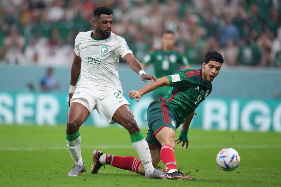 Mexican forward Raúl Jiménez challenges Saudi Arabian midfielder Riyadh Sharahili for the ball during a 2022 FIFA World Cup match. Image used for Sportxparte news.