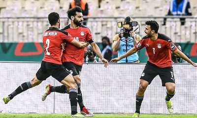 Mohamed Salah is celebrating with his teammates Mohamed Abdelmonem (left) and Trézéguet (right) during the Egypt national football team's extra-time victory over Morocco in the AFCON quarterfinals. Image used for Sportxparte news.