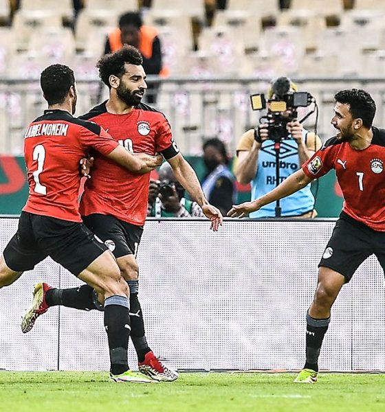Mohamed Salah is celebrating with his teammates Mohamed Abdelmonem (left) and Trézéguet (right) during the Egypt national football team's extra-time victory over Morocco in the AFCON quarterfinals. Image used for Sportxparte news.