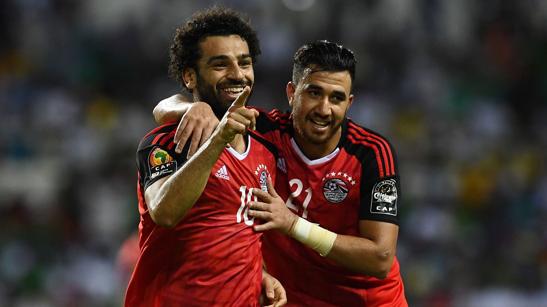 Mohamed Salah celebrating a goal alongside Mahmoud 'Trezeguet' Hassan during a 2022 World Cup qualifier match against Senegal. Image used for Sportxparte news.
