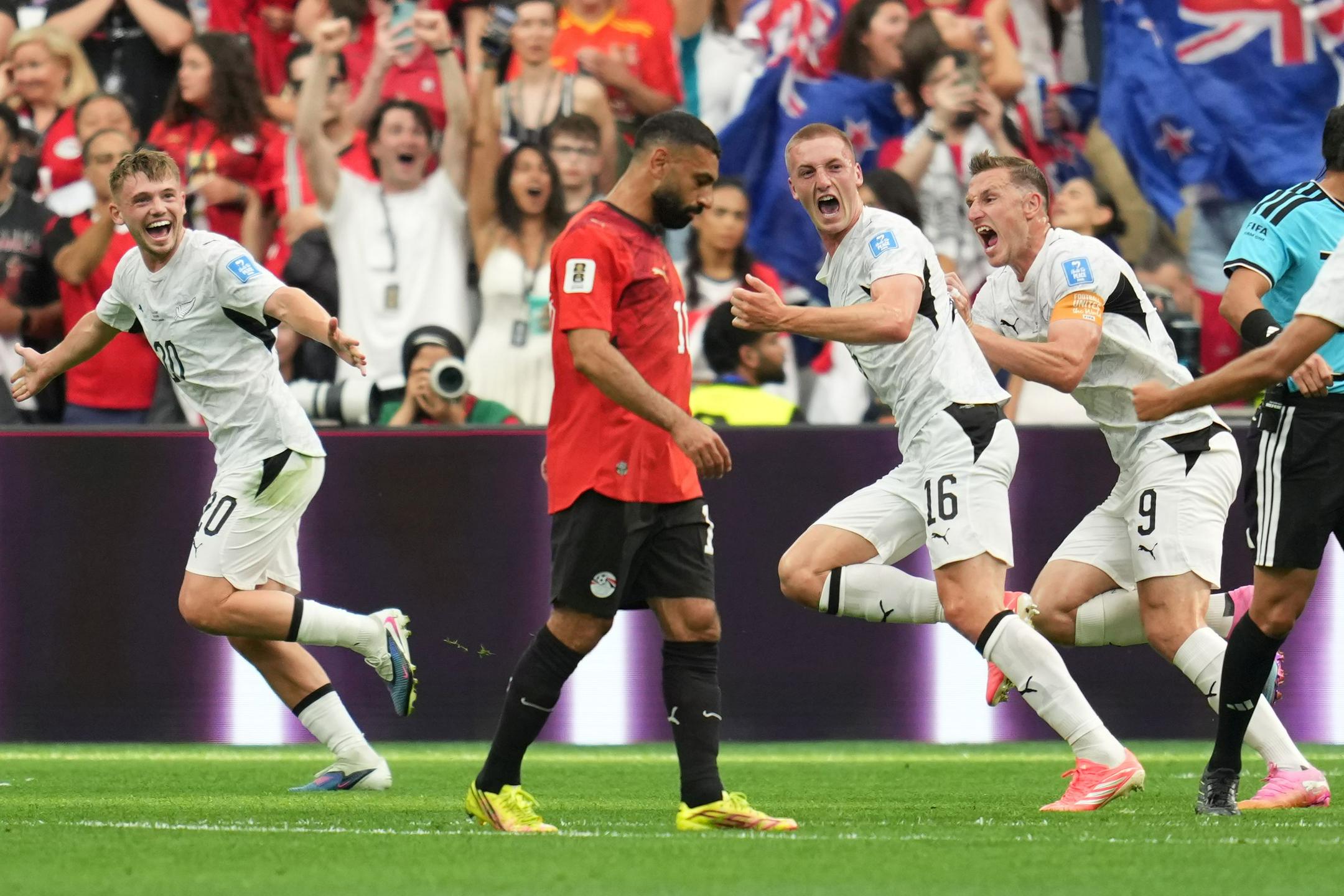 New Zealand soccer players Finn Surman, Ben Old, and Tim Payne celebrate a goal past a dejected Mohamed Salah of Egypt during a 2026 FIFA World Cup match. Image used for Sportxparte news.