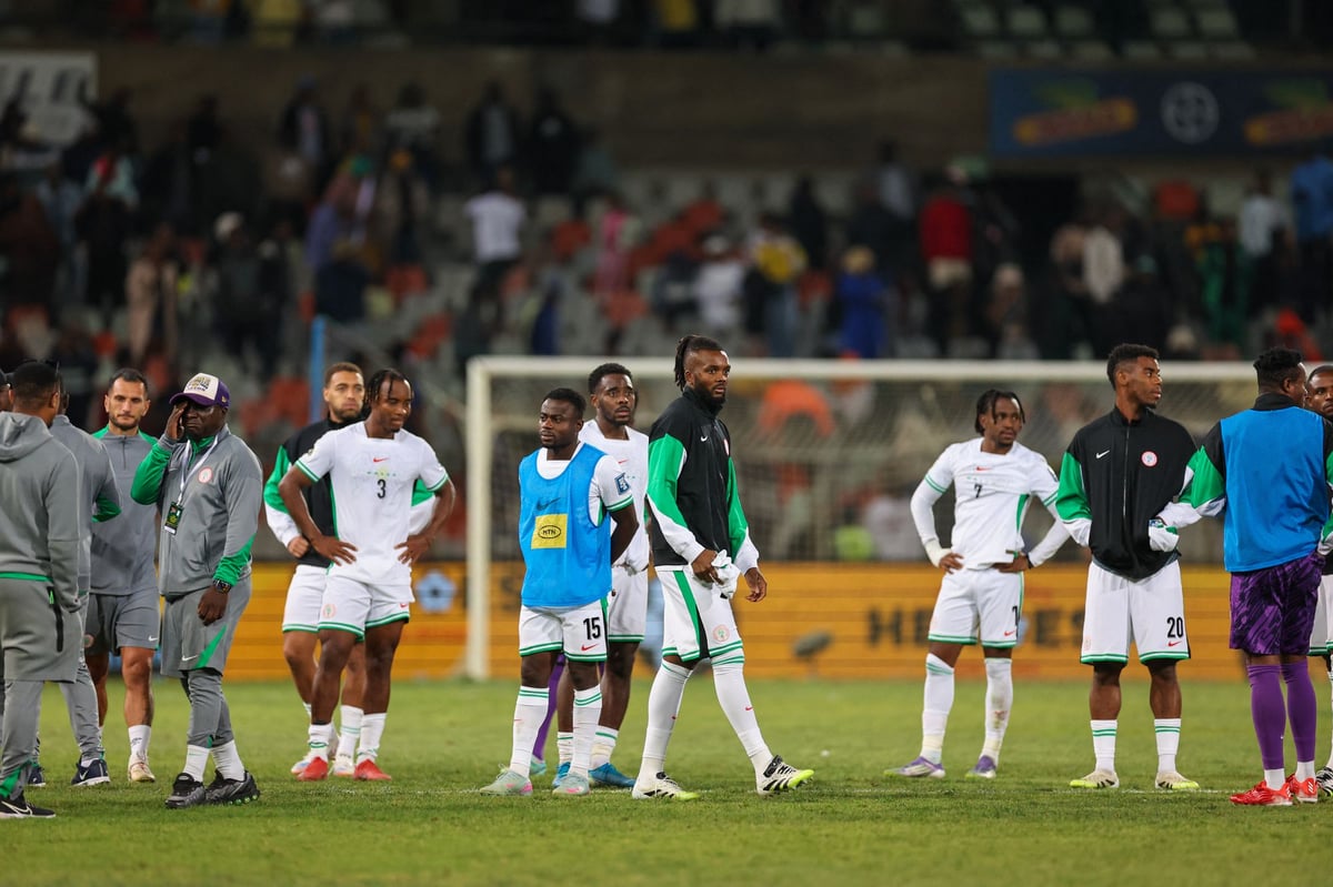 A group of players and staff from the Nigeria men's national football team, the Super Eagles, stand on a stadium pitch looking dejected or pensive. Image used for Sportxparte news.