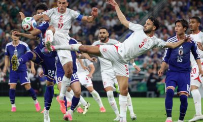 Tunisia's Montassar Talbi #3 and Ellyes Skhiri #17 battle mid-air with Japan's Takehiro Tomiyasu #22 for a soccer ball during the 1,000th World Cup match. Image used for Sportxparte news.