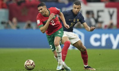 Kylian Mbappé of France wearing a blue Nike jersey and Achraf Hakimi of Morocco wearing a red Puma kit during the 2022 World Cup semi-final. Image used for Sportxparte news.