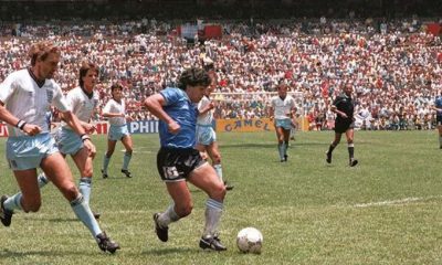 Diego Maradona dribbling past English defenders during the iconic Argentina v England quarterfinal match at the 1986 FIFA World Cup. Taken on June 22, 1986, at the Estadio Azteca in Mexico City, this specific moment shows Maradona embarking on his famous solo run to score what was later voted the "Goal of the Century. Image used for Sportxparte news.