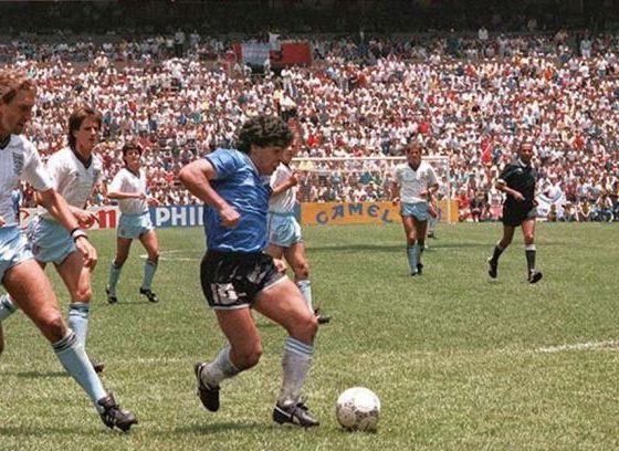 Diego Maradona dribbling past English defenders during the iconic Argentina v England quarterfinal match at the 1986 FIFA World Cup. Taken on June 22, 1986, at the Estadio Azteca in Mexico City, this specific moment shows Maradona embarking on his famous solo run to score what was later voted the "Goal of the Century. Image used for Sportxparte news.