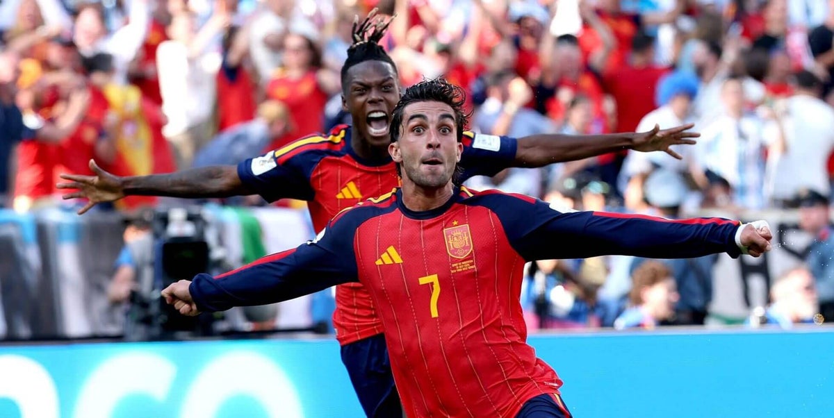 Spanish national team forward Ferran Torres (#7) and winger Nico Williams celebrate enthusiastically with arms outstretched after Torres scored the historic extra-time winning goal against Argentina in the 2026 FIFA World Cup Final, captured inside the New York New Jersey Stadium in front of a packed crowd of fans dressed in red. Image used for Sportxparte news.