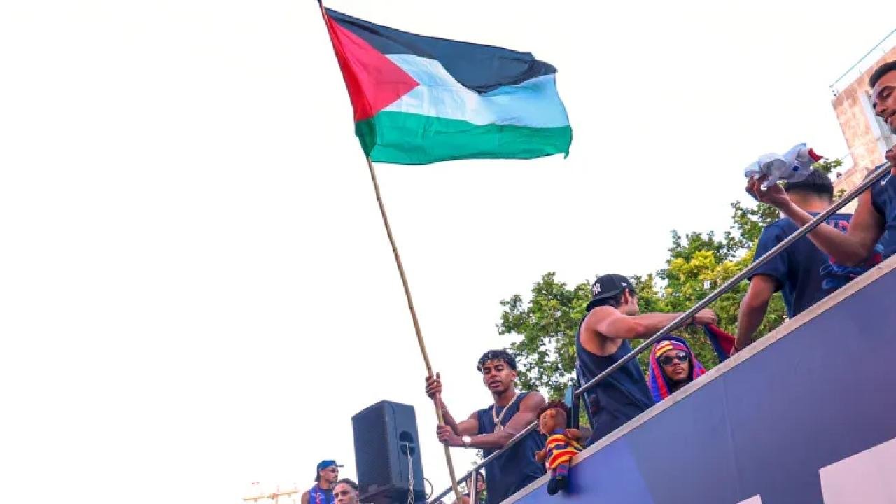 FC Barcelona player Lamine Yamal holding a Palestinian flag. He unfurled and waved the flag atop an open-top bus while celebrating with his teammates after winning the Spanish La Liga title in Barcelona, Spain, on May 11, 2026. Image used for Sportxparte news.
