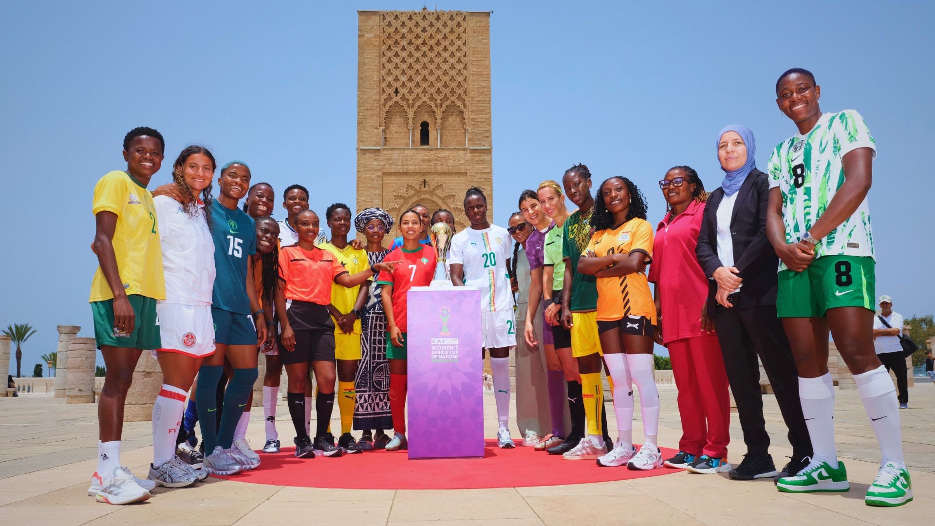 Female football players from various national teams posing with the new TotalEnergies CAF Women's Africa Cup of Nations trophy at the Hassan Tower in Rabat, Morocco. Image used for Sportxparte news.