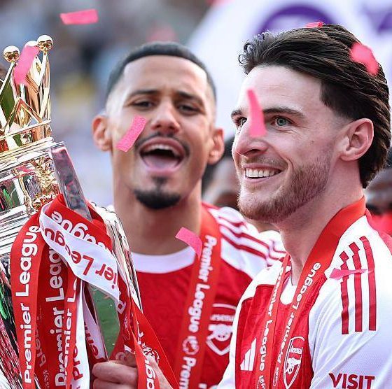 Arsenal midfielder Declan Rice celebrating with teammates after winning the Premier League trophy in May 2026, ending the club's 22-year wait for the league title. Image used for Sportxparte news.