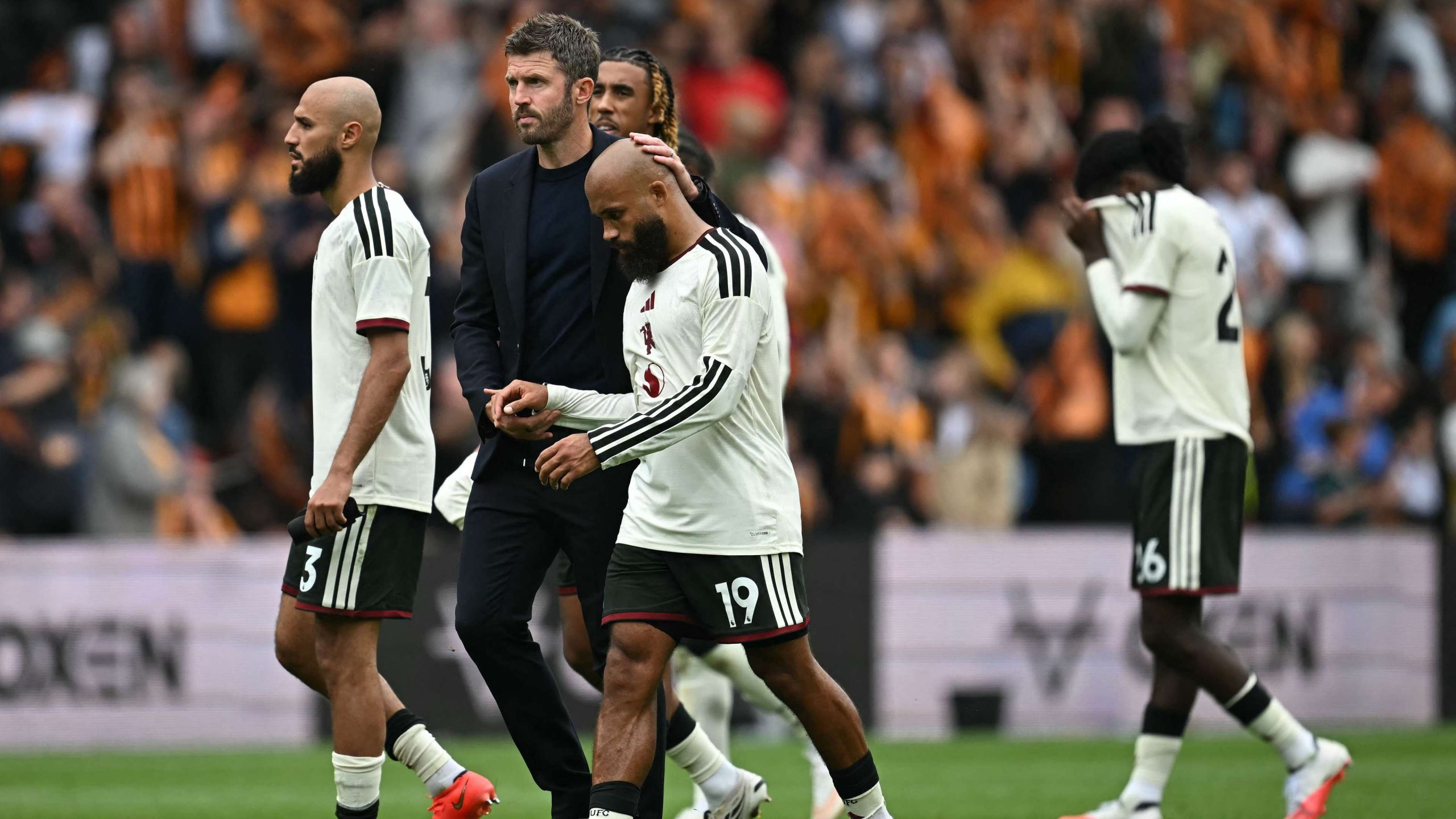 Manchester United manager Michael Carrick consoling player Andrey Santos after he was substituted off during a 2-0 Premier League opening defeat against newly-promoted Hull City at the MKM Stadium on August 22, 2026. Image used for Sportxparte news.