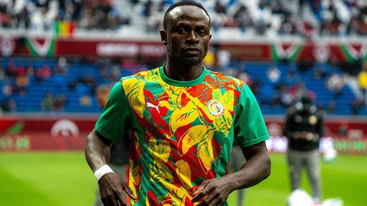 Sadio Mané during his time playing for the Senegal national football team. He is pictured wearing Senegal's distinct, vibrant green warmup jersey featuring bold yellow and red leaf-like patterns. Image used for Sportxparte news.