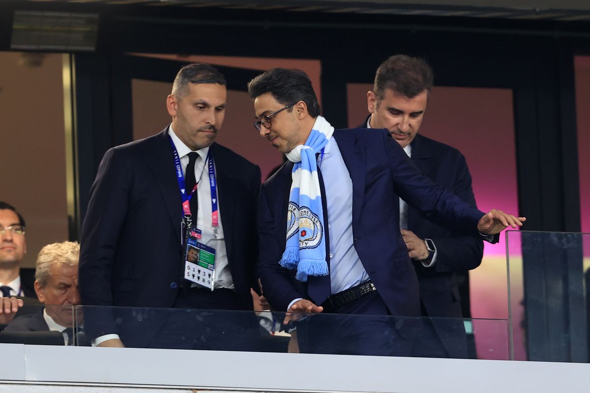 Manchester City owner Sheikh Mansour wearing a club scarf alongside chairman Khaldoon Al Mubarak in the stadium stands. Image used for Sportxparte news.