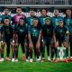 High-quality squad photo of the Nigeria Super Falcons players wearing their iconic green home kits, featuring stars like Chiamaka Nnadozie, Rasheedat Ajibade, and Michelle Alozie during the 2026 WAFCON tournament. Image used for Sportxparte news.